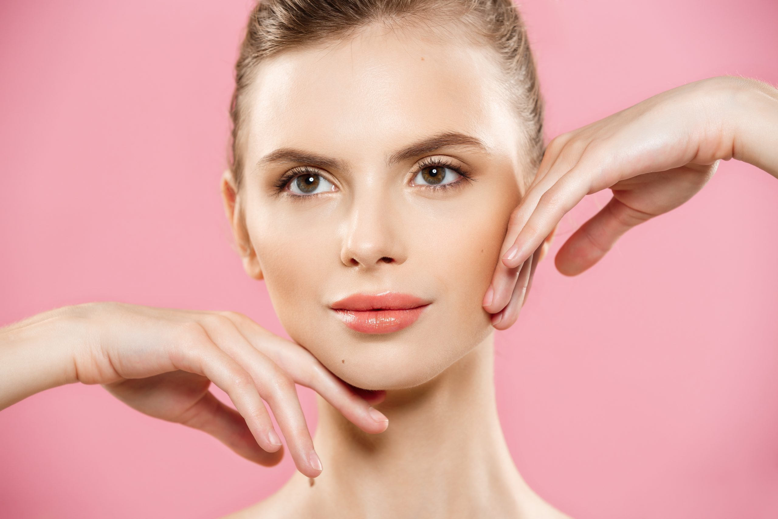 Beauty spa concept caucasian woman with perfect face skin portrait. beautiful brunette spa girl showing empty copy space. isolated on pink studio background. proposing a product. gesture for advertisement.